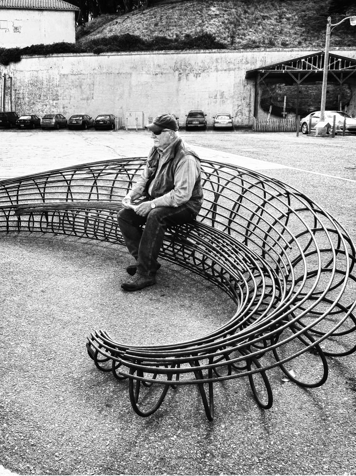 solitary man on a metal bench, urban