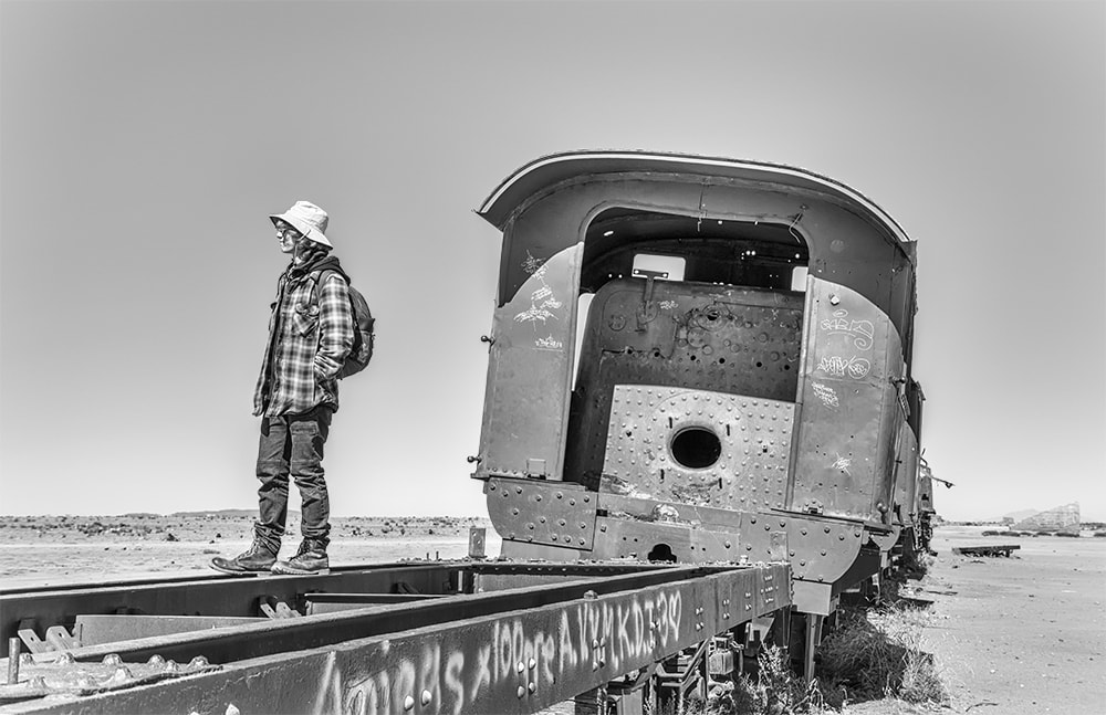 old train car, black and white, man on train tracks