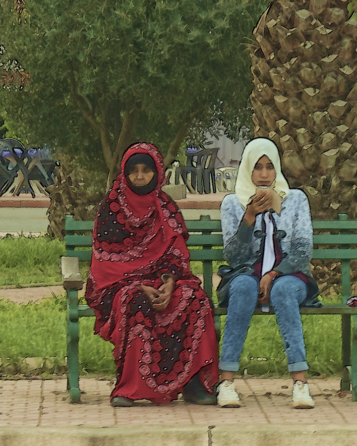 older and younger woman on bench, djellaba, jeans, head coverings, generations